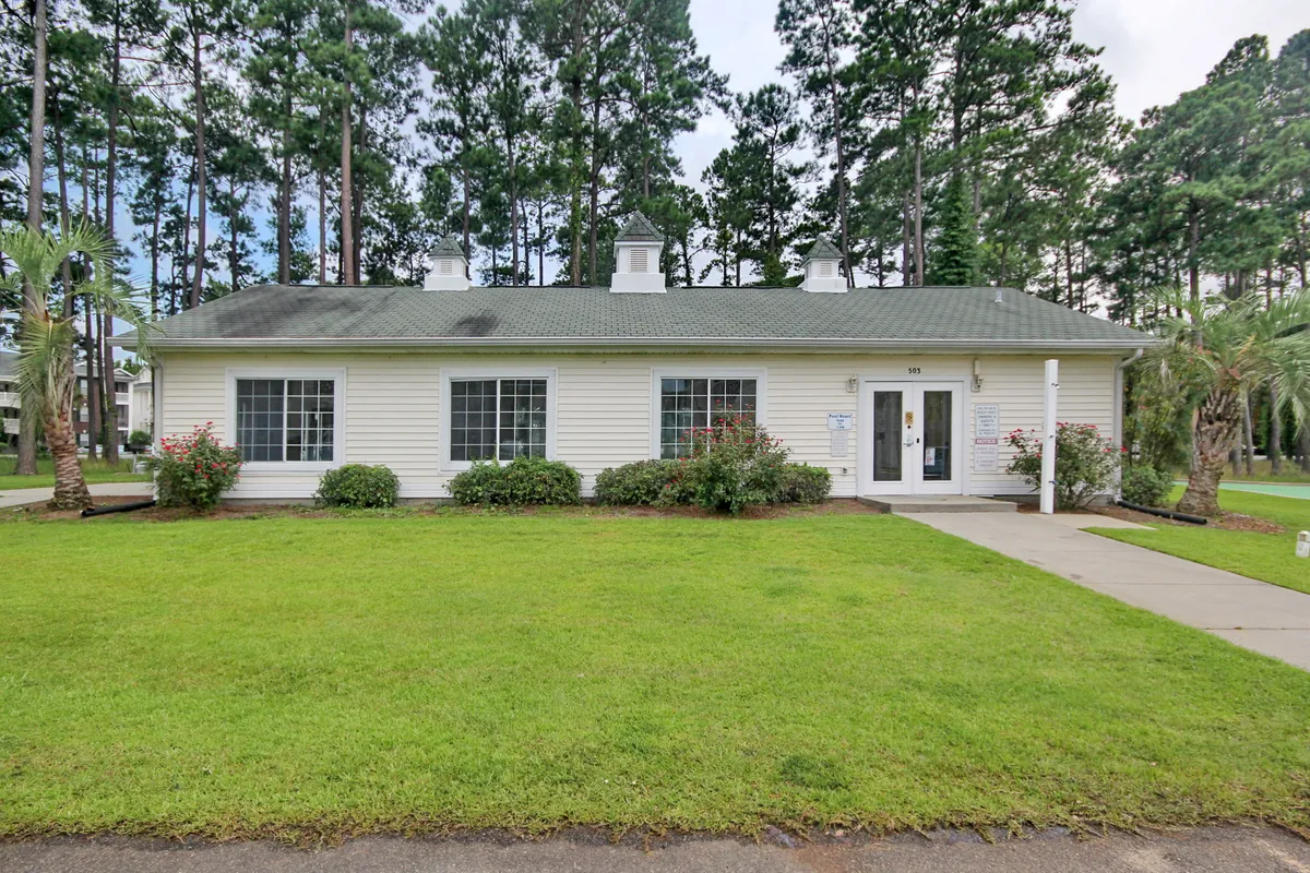 This exterior shot showcases a well-maintained lawn, the front entrance of the property, and surrounding trees, all bathed in welcoming natural light. The image suggests easy access and a pleasant home base for coming and going during family adventures.